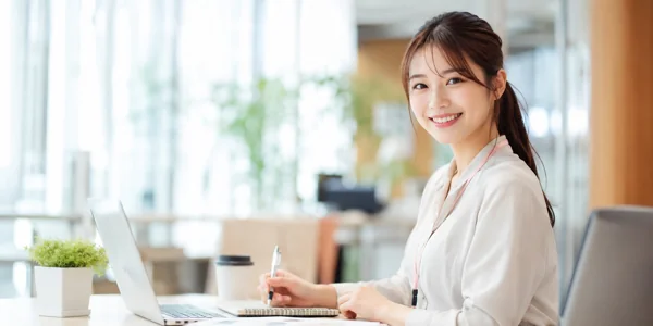 笑顔でデスクワークする女性社員