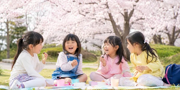 桜の下でお花見する子どもたち
