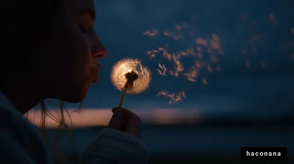 たんぽぽの種を吹く少女