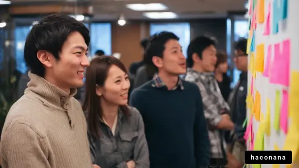 壁に貼られた付箋を見守る人々