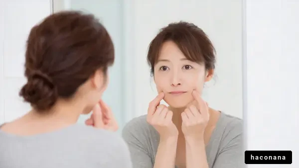 鏡で肌をチェックする女性